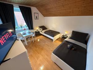 um quarto com duas camas, um sofá e uma mesa em 3-Zimmer Apartment für Monteure & Geschäftsreisende: Schnelles Internet em Stemshorn