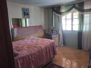 1 dormitorio con cama y ventana en Casa c/Piscina em Arroio do Rosa en Imbituba