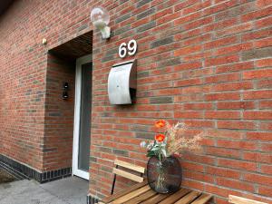 um vaso de flores sentado num banco ao lado de um edifício em 3-Zimmer Apartment für Monteure & Geschäftsreisende: Schnelles Internet em Stemshorn