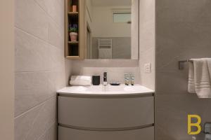 a bathroom with a white sink and a mirror at BePlace Apartments in Gioia in Milan