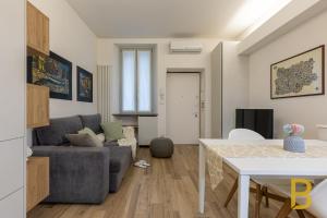 een woonkamer met een bank en een tafel bij BePlace Apartments in Gioia in Milaan