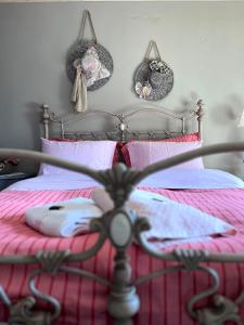 a bedroom with a bed with pink sheets and pink pillows at Petrameli in Karpenisi
