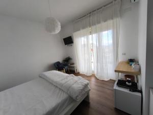 een witte slaapkamer met een bed en een raam bij Seconda Stella a Destra in Napels