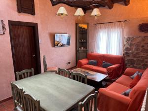 uma sala de estar com um sofá, uma mesa e cadeiras em Casa Juan em Orihuela del Tremedal