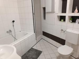 een badkamer met een toilet, een bad en een wastafel bij Ferienwohnung-Haus in Saarbrücken in Saarbrücken