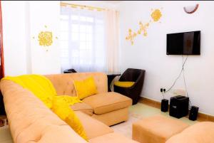 a living room with a couch and a television at Garden estate thika road in Nairobi