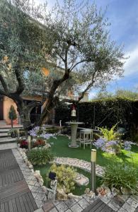 un giardino con un albero in mezzo a un cortile di Aurelia Garden Gold B&B a Roma