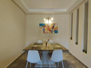 una sala da pranzo con un tavolo e due sedie bianche di RM 15 by Majestic Properties a Marrakech