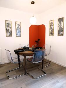 ein Esszimmer mit einem Tisch und 3 Stühlen in der Unterkunft Gîte-appartement RDC La Ville au Monnier in Pleurtuit