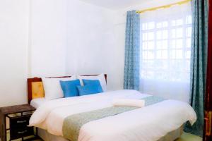 a bedroom with two beds and a window at Garden estate thika road in Nairobi