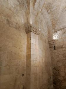 una pared de piedra con una columna en un edificio en Dimora Dante 310, en Bari