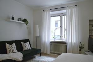 sala de estar con sofá verde y ventana en Modern and Bright Studio with Top Location, en Helsinki