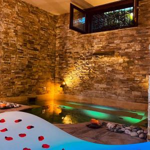 a bath tub in a room with a stone wall at Aurelia Garden Gold B&B in Rome