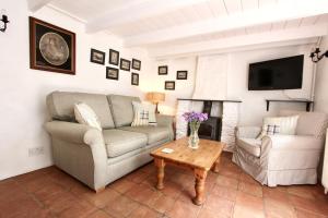 a living room with a couch and a table at Ginentonic Cottage in Saint Keverne +25 photos