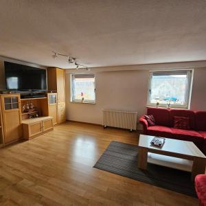 een woonkamer met een rode bank en een tafel bij Main zu Hause in Eichenbühl