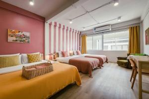 ein Hotelzimmer mit 2 Betten und einem Sofa in der Unterkunft Sukhumvit entire house 7 pax - 2 mins walk from skytrain in Bangkok