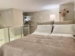 Un dormitorio con una cama grande con almohadas blancas. en Koselig leilighet i sentrum av OSLO med byutsikt!, en Oslo