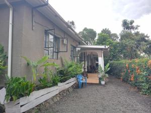 una casa con una silla azul delante de ella en Arusha-paradise-home, en Nkoanrua