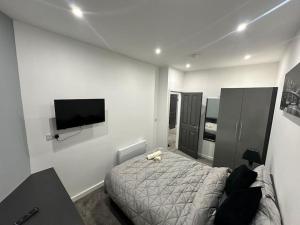 a bedroom with a bed and a flat screen tv at Luxurious 2 bedroom flat in Beeston Hill