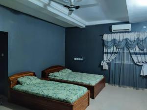 2 camas en una habitación con paredes azules en Belle Villa en Lomé