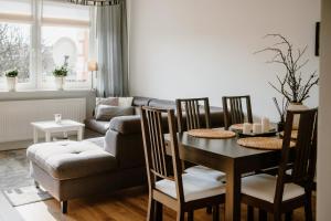 a living room with a table and a couch at Apartament White in Giżycko