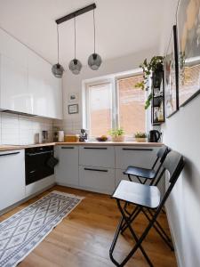 a kitchen with a table and a chair in it at Apartament White in Giżycko +8 photos