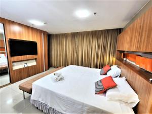 Bloco A AP 310 · Hotel Jade, Park Sul vista livre في برازيليا: غرفة نوم بسرير ابيض كبير وتلفزيون بشاشة مسطحة