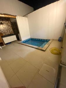 a swimming pool in a room with a hose at Casa pertinho da praia doTombo in Guarujá