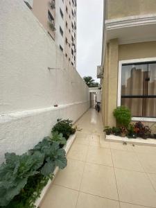 a hallway of a building with plants on it at Casa pertinho da praia doTombo in Guarujá