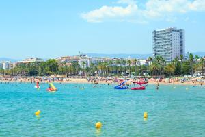 a beach with a bunch of people in the water at NEW VALENCIA 2 Planetcostadorada in Salou