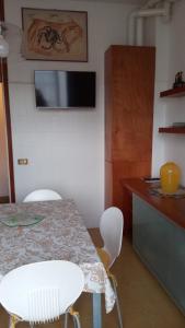 a kitchen with a table and chairs and a television at Angela Home in Rimini