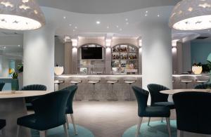 a bar in a restaurant with tables and chairs at Hotel Arts in Calgary