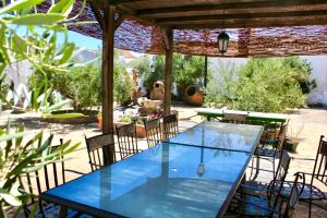 a glass table and chairs on a patio at Casa Rural Las Grullas in El Hito