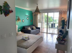 a living room with a bed and a couch at Couleur caraïbes appartement dans un hôtel 3 étoiles vue mer in Sainte-Luce