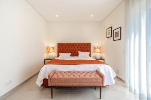 a bedroom with a large bed and two windows at Holiday House Beach Porto Mós by Villas Key in Lagos +36 photos