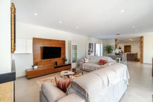 a living room with a couch and a tv at Holiday House Beach Porto Mós by Villas Key in Lagos