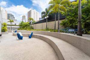 un parc avec des chaises bleues et des palmiers dans une ville dans l'établissement Predio completo ao lado da Faria Lima - KASA, à São Paulo