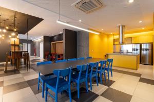 une salle à manger avec une table et des chaises bleues dans l'établissement Predio completo ao lado da Faria Lima - KASA, à São Paulo
