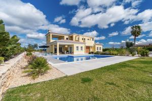 a villa with a swimming pool and a house at Holiday House Beach Porto Mós by Villas Key in Lagos
