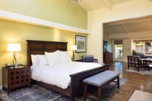 a bedroom with a large bed and a living room at The Quail Lodge in Carmel