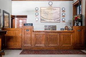 a wooden counter in a room with clocks on the wall at Gardner Hotel & Hostel in El Paso