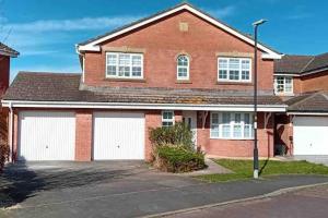 a brick house with two white garage doors at Large Lytham Home - The Birds View by Holiday Heim in Lytham St Annes