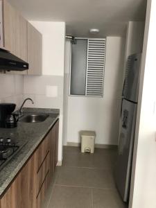 a kitchen with a sink and a refrigerator at Apartamento central in Manizales