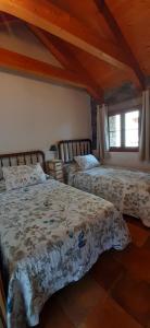 1 dormitorio con 2 camas y ventana en Casa Castillón, en Ceresa
