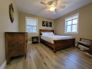 a bedroom with a bed and a ceiling fan at Firefly Hut - Cheerful 6-bedroom cottage with serene beauty in McDougall