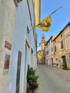 een gele vlag aan de zijkant van een gebouw op een straat bij La casina nel convento in Asciano