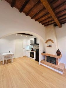 a large kitchen with white walls and a wooden ceiling at La casina nel convento in Asciano