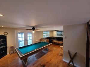 a living room with a pool table in it at Firefly Hut - Cheerful 6-bedroom cottage with serene beauty in McDougall