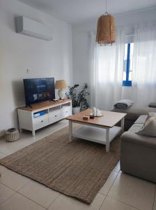 a living room with a couch and a tv at Marina Gardens in Paphos