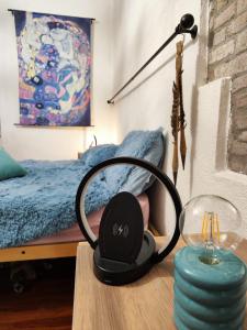 auriculares sentados en una mesa junto a una cama en La casa della mamma en Gubbio